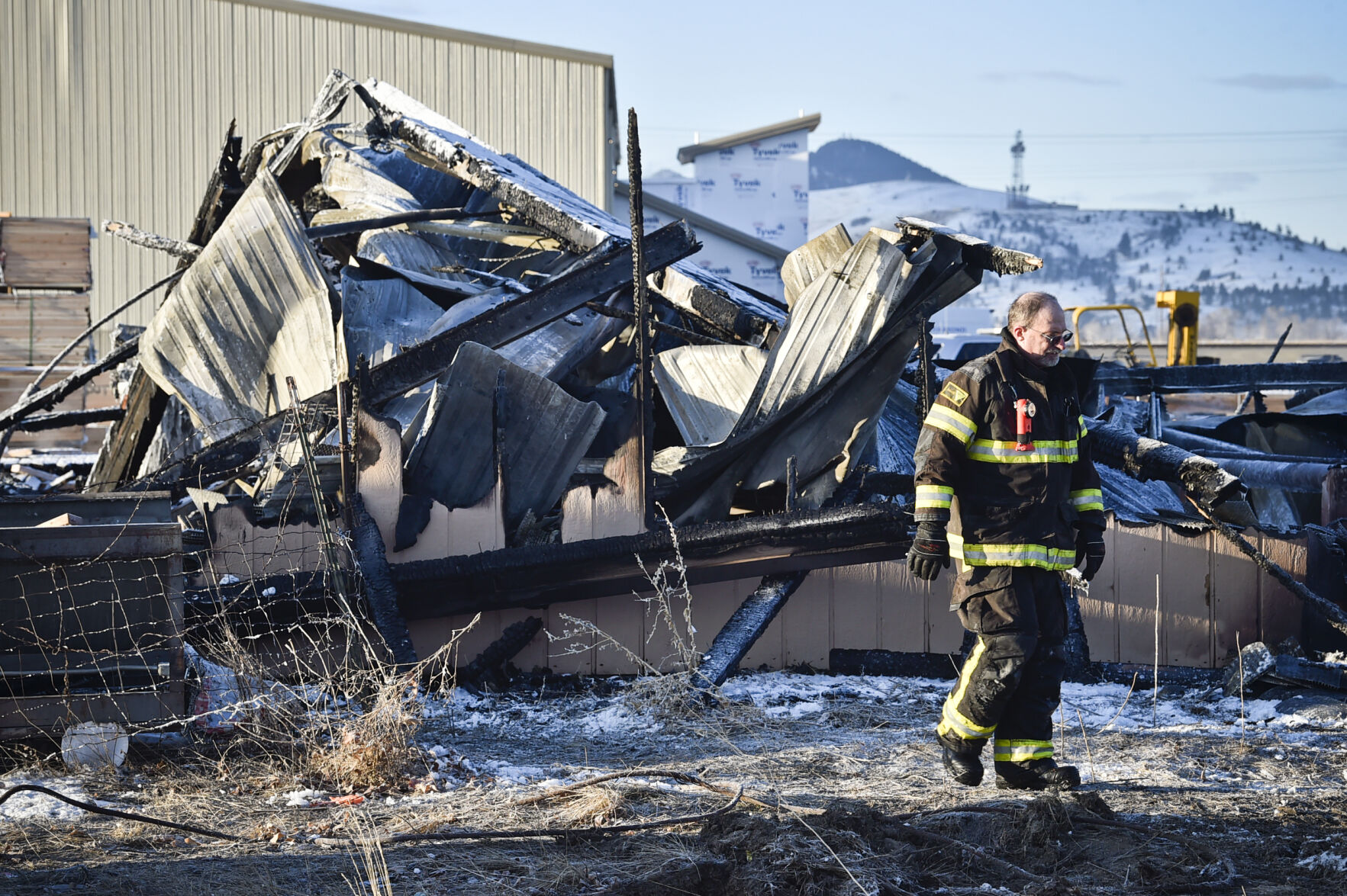 An East Helena firefighter walks through the remains of the Casey Truss Company